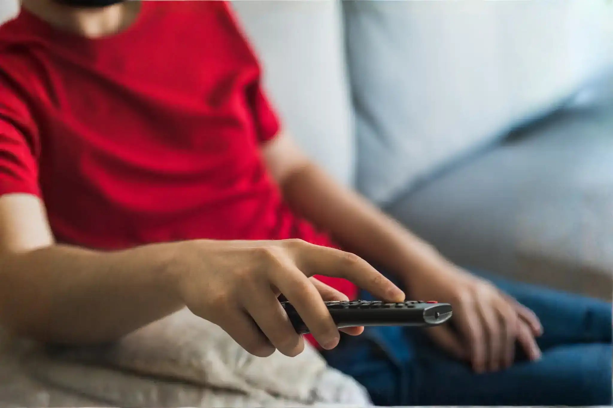 Persona sentada viendo la televisión, ejemplo de sedentarismo relacionado con la pérdida de masa muscular